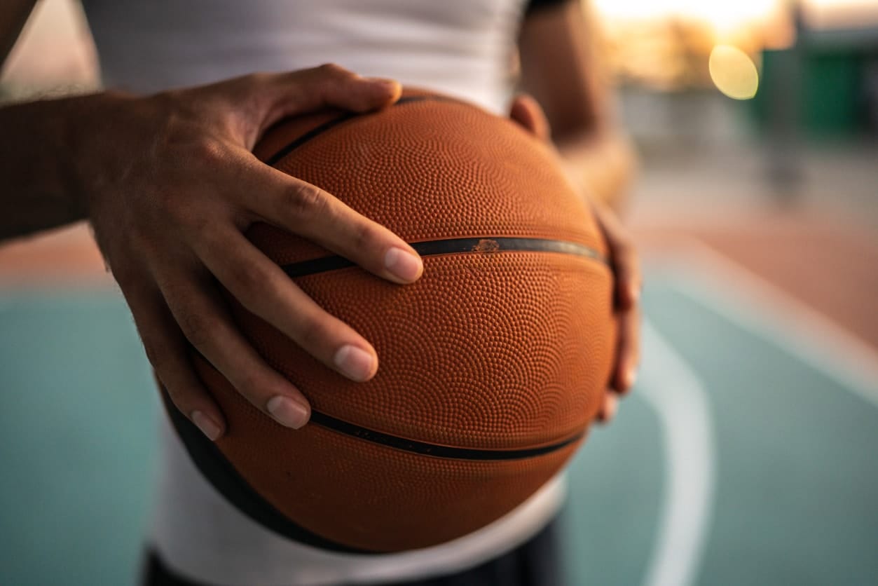 Close up of man with basketball ball at sports field