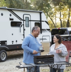 Mature multiracial couple at RV park, grilling